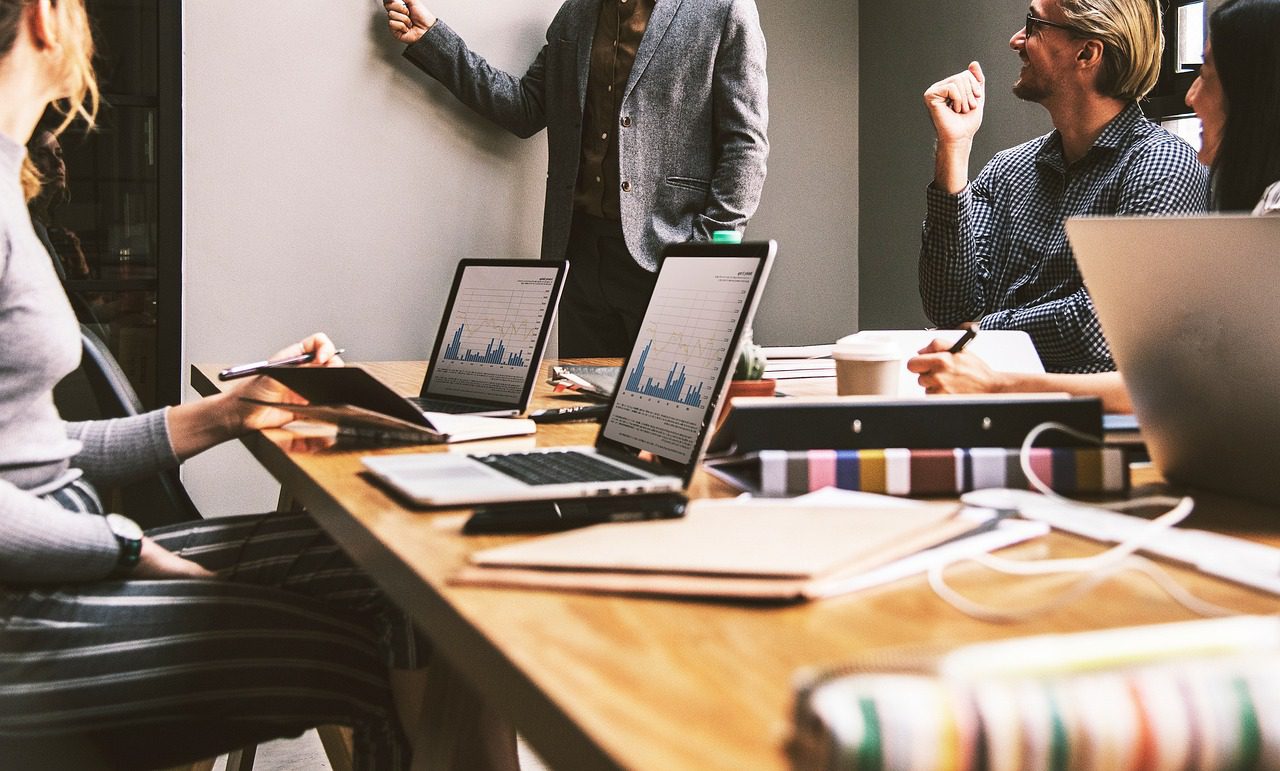 Sales team collaborating in an office, illustrating the benefits of sales outsourcing companies.