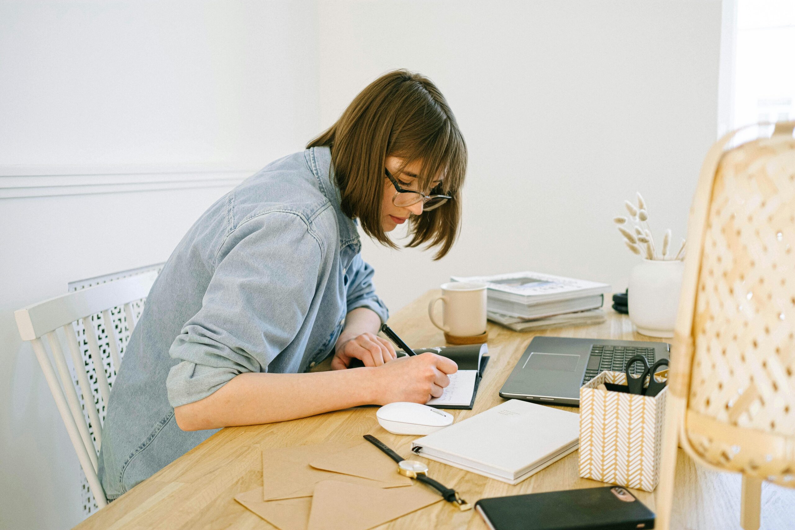 Offshore staffing agency employee working at her desk, taking notes and managing tasks