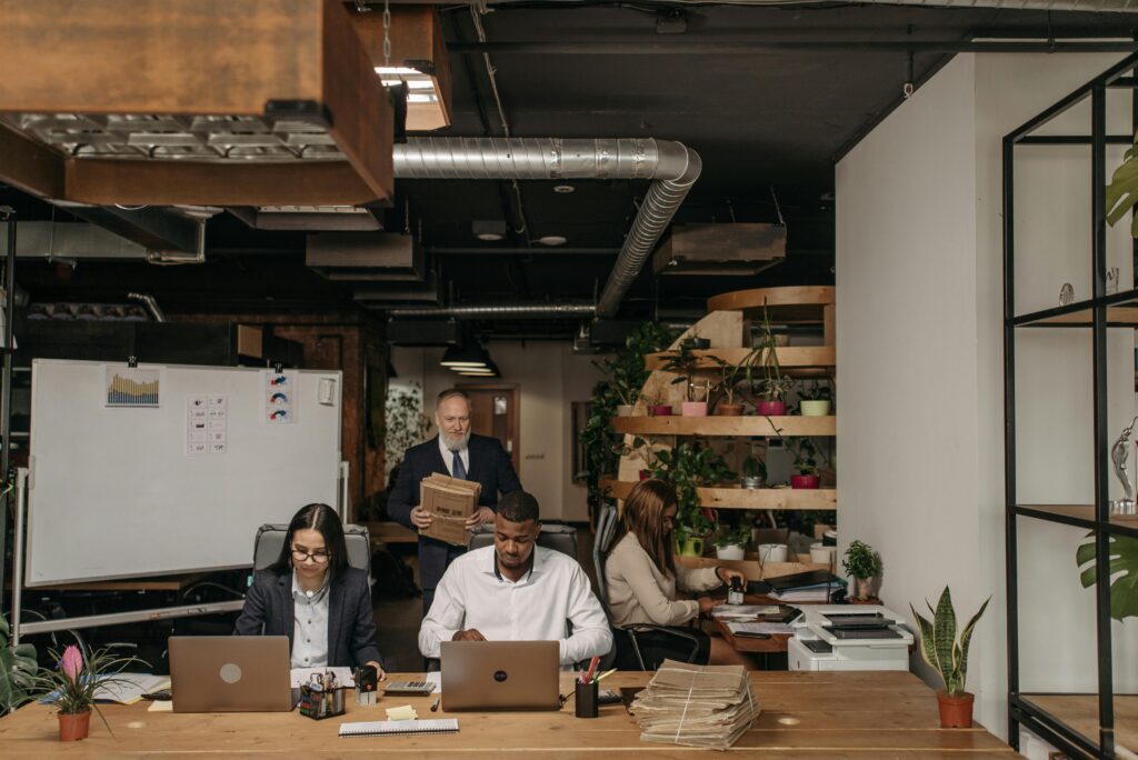 Team working in a modern office with laptops and documents, representing talent acquisition services and efficient hiring processes 