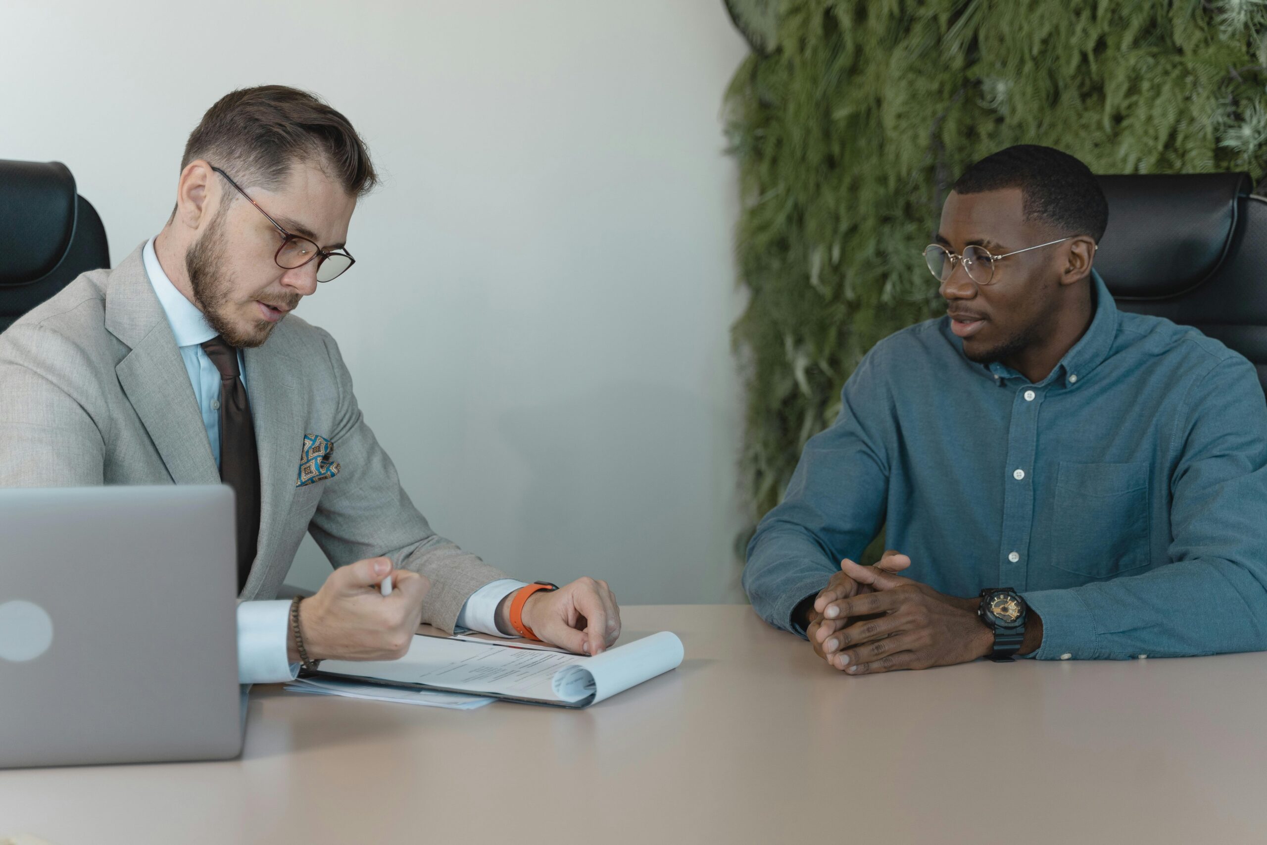 Employer of Record (EOR) consultation meeting with a hiring manager reviewing employment documents with an international employee in an office setting