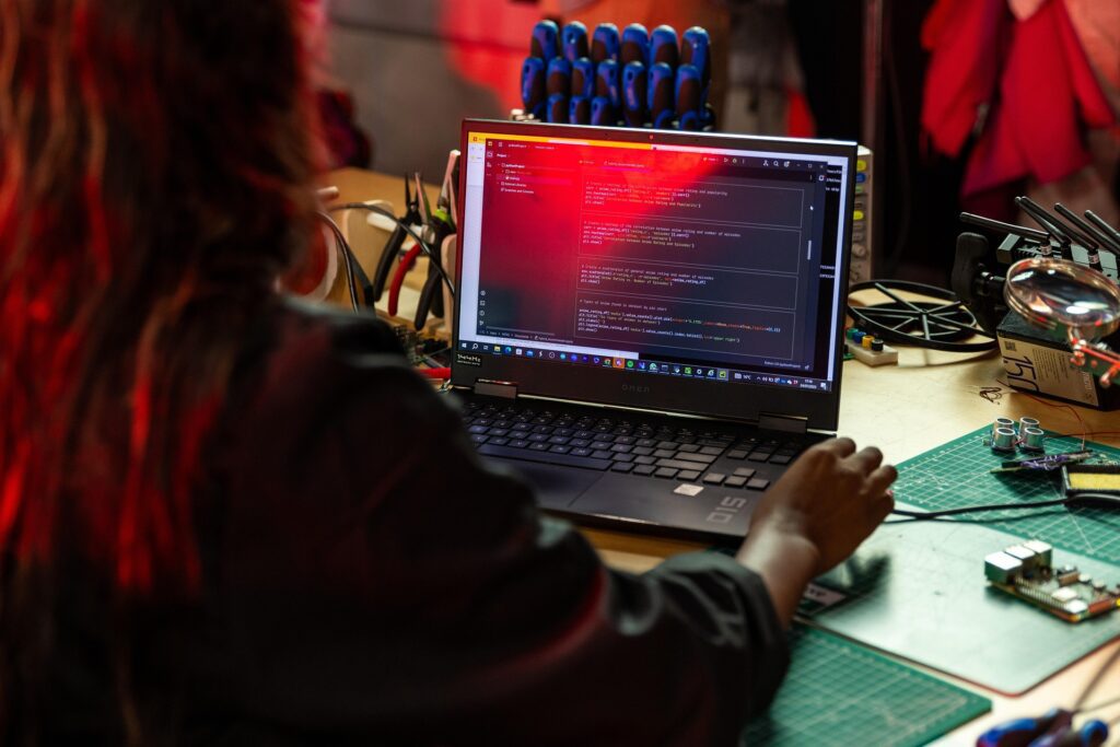 Software engineer working on code at a laptop in a workshop, representing the type of talent sourced by software engineer recruitment agencies.