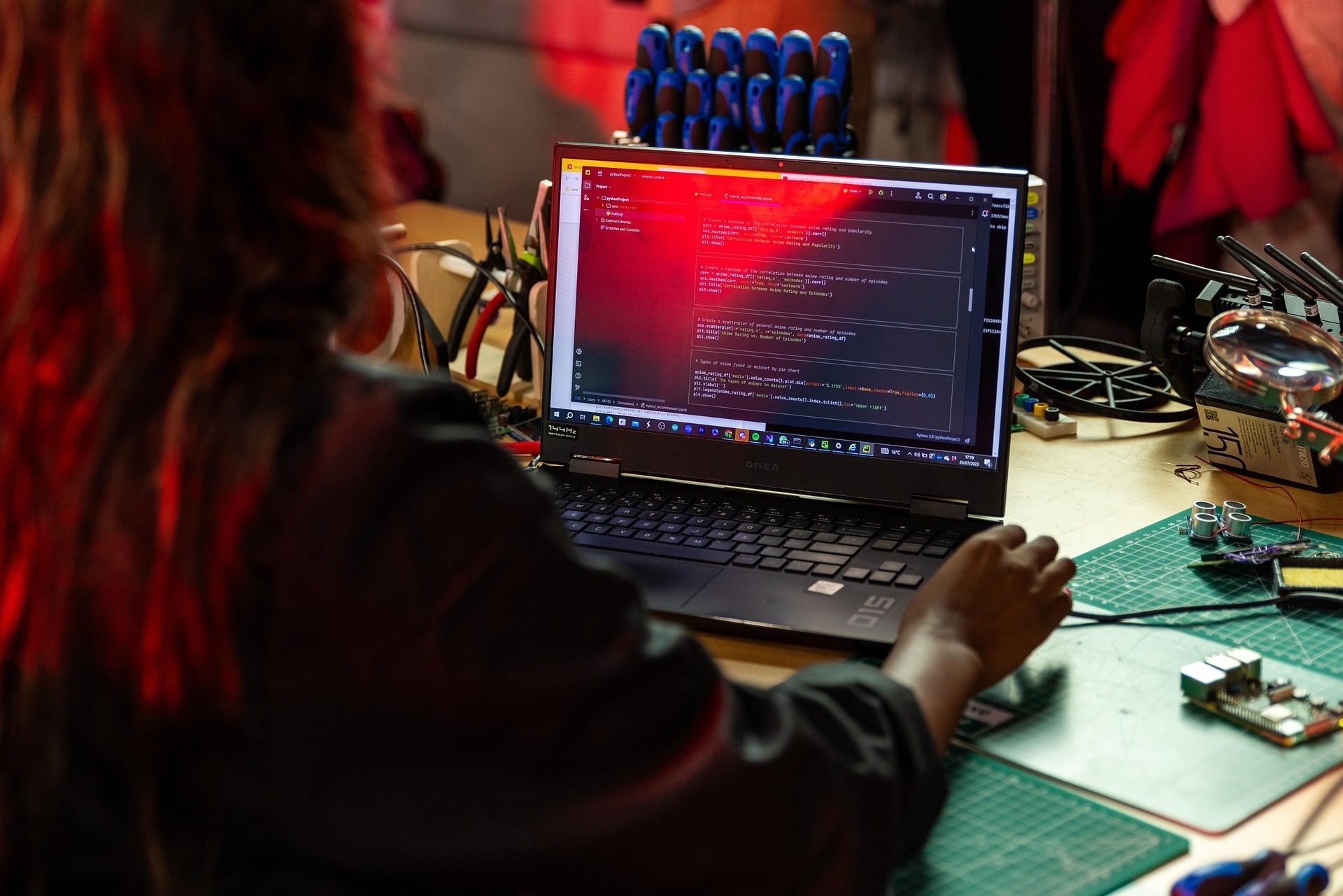 Software engineer working on code at a laptop in a workshop, representing the type of talent sourced by software engineer recruitment agencies.